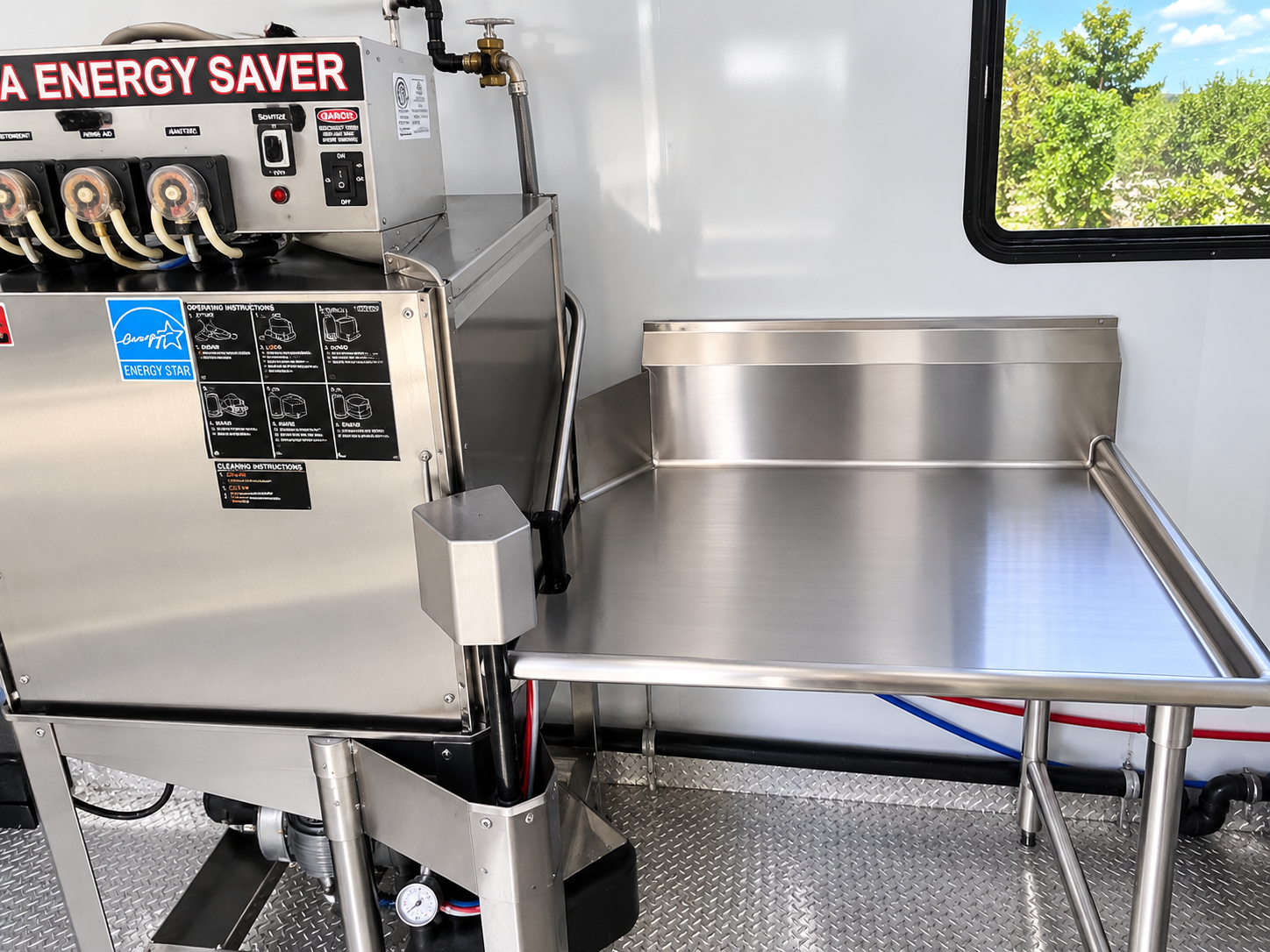 Commercial dishwasher machine beside a stainless work surface