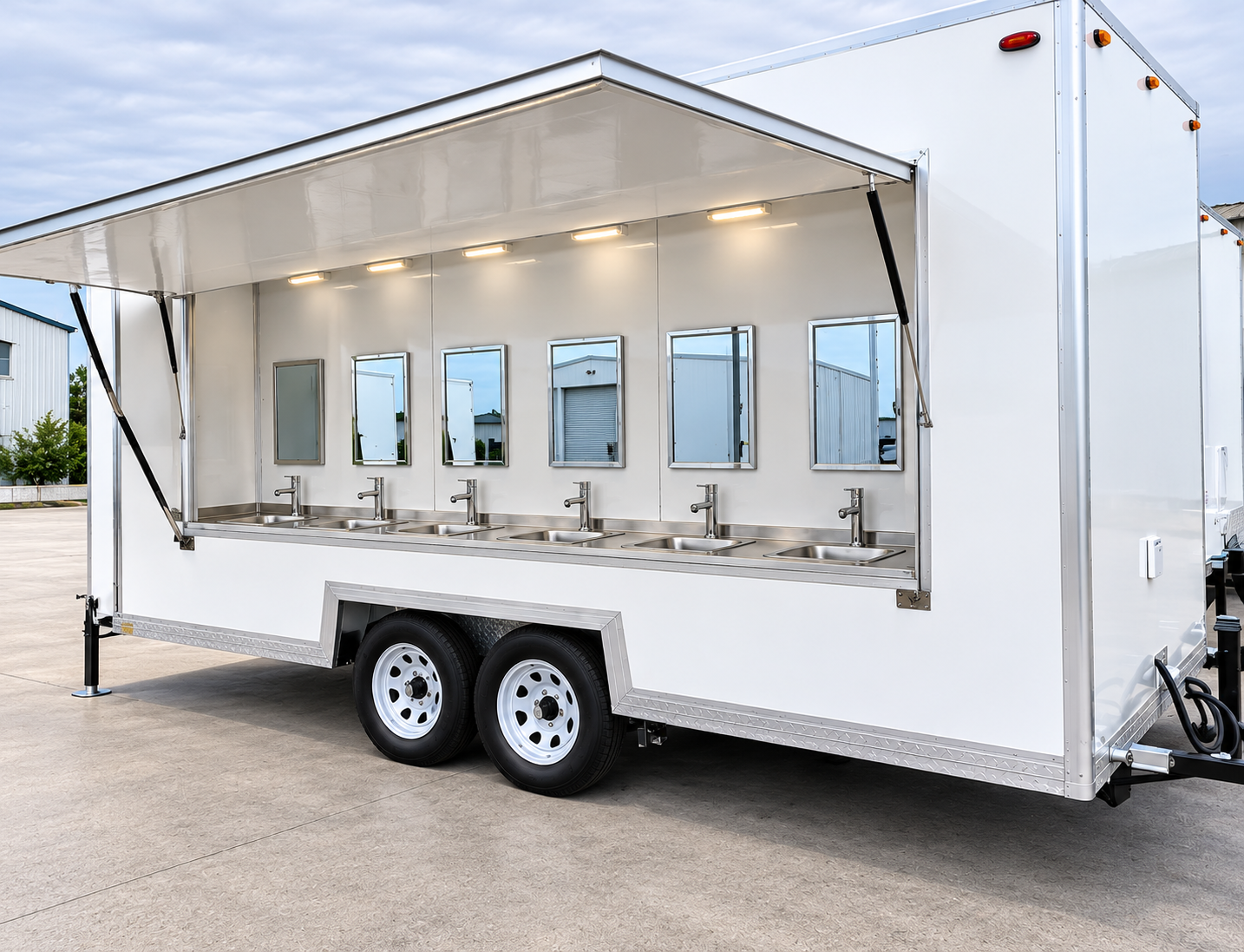 Side view of a white trailer with handwashing sinks and a raised canopy